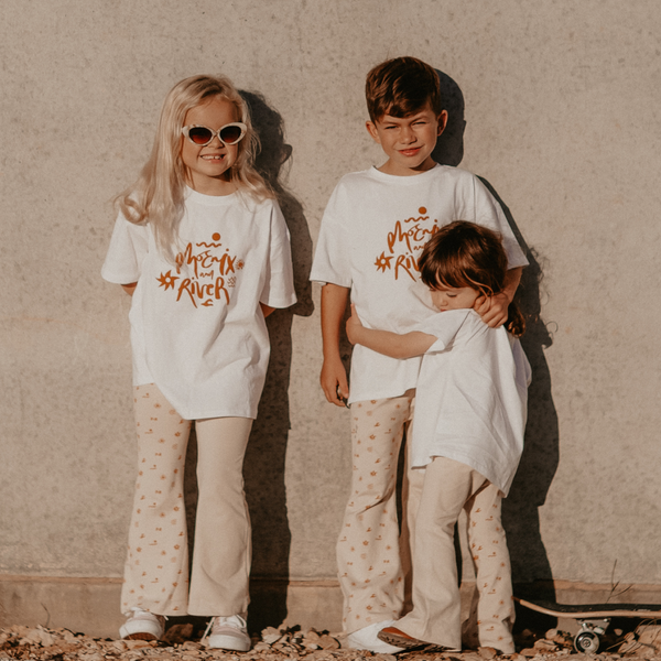 two girls and a boy wearing the Sun Dance Tee and Flares