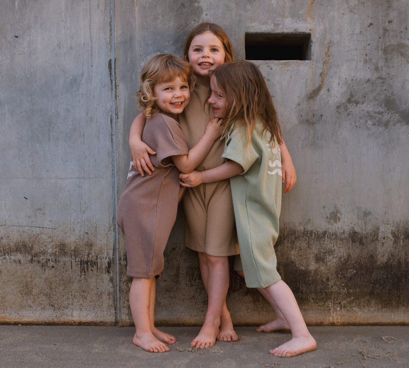 Three girls wearing Sunset Romper in different colours